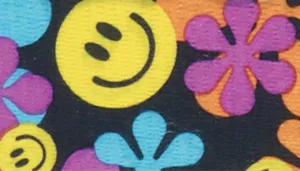 A swatch featuring a vivid floral pattern on a black background. Bright smiley‑face icons in yellow appear alongside bold flowers in purple, pink, and blue, each with simple petal shapes and thick outlines. The design is upbeat and retro‑inspired, with strong saturation and a smooth printed surface.