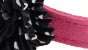A swatch showing a decorative black flower embellishment attached to a pink strap. The flower consists of layered black fabric petals with ruffled edges, forming a voluminous rosette. The strap beneath is soft matte pink with faint stitching visible at the edges, providing contrast against the dark floral accent.