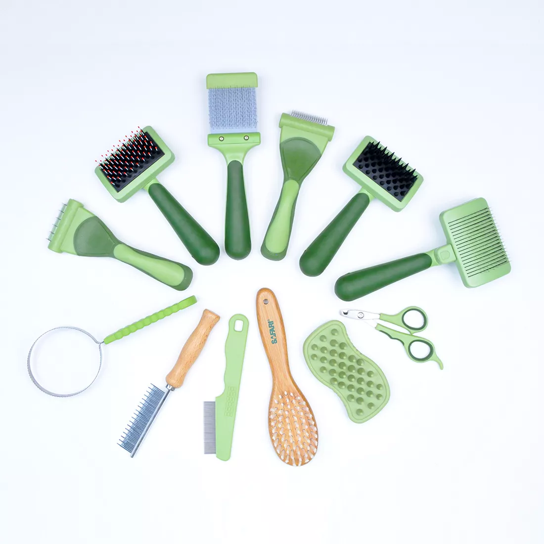 A collection of green grooming tools is arranged on a white background. The set includes multiple brushes, combs, cutters, and grooming accessories in shades of pale and dark green, each with textured grips or molded handles. Various brush head shapes, comb designs, and tool forms are visible across the arranged layout.