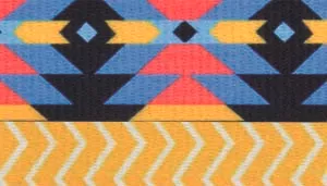 A rectangular swatch featuring a bold Southwestern‑inspired pattern. The top portion contains geometric motifs in navy, sky blue, coral, and black arranged in angular, repeating shapes reminiscent of traditional Aztec artwork. The lower half displays a bright mustard‑yellow chevron pattern with evenly spaced zigzag stripes. The overall palette is vibrant and high‑contrast, combining warm and cool tones within a visually striking layered design.